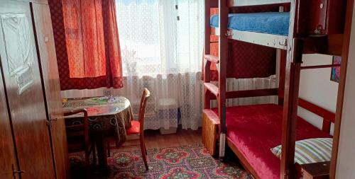 a bedroom with a bunk bed with a table and a window at Room for you in Warsaw