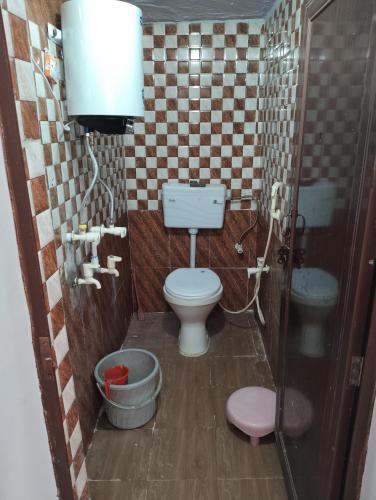 a small bathroom with a toilet and a sink at Thakur Shri Dwarkadhish Seva Sadan in Mathura
