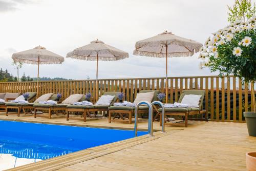 a row of chairs and umbrellas next to a pool at Babka in Białka Tatrzańska