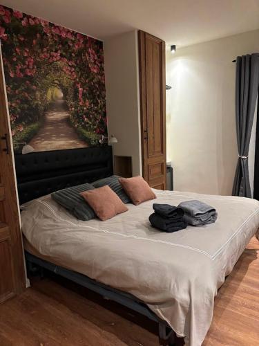 a bedroom with a bed with a painting on the wall at Snow&Rose in Damme