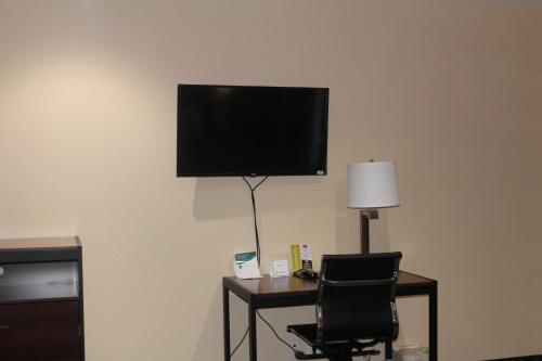 a desk with a chair and a television on a wall at Americas Best Value Inn-Near NRG Park/Medical Center in Houston