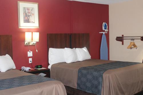 a hotel room with two beds and red walls at Americas Best Value Inn-Near NRG Park/Medical Center in Houston