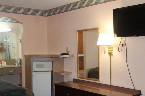 a hotel room with a television on a wall at Americas Best Value Inn-Near NRG Park/Medical Center in Houston