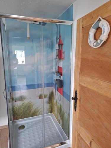 a glass shower door with a picture of a lighthouse at Pension Fiete Celle in Celle