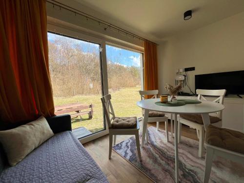 a living room with a table and a large window at Domek Ranczo Podkówka "przed" Bieszczady in Lipa