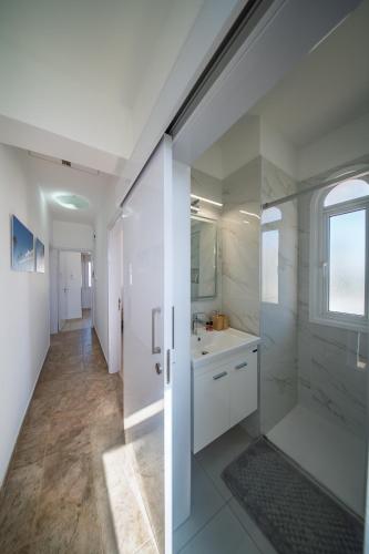 a white bathroom with a sink and a shower at Palm Villa Eva in Paralimni