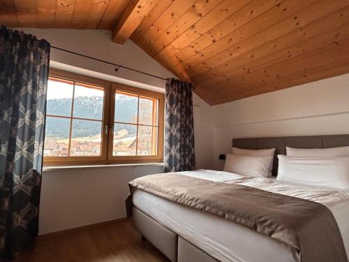 a bedroom with a bed and a large window at Landhaus Sonnenwang in Pfronten