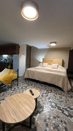a hotel room with a bed and two tables at Adonai, departamentos in El Bolsón