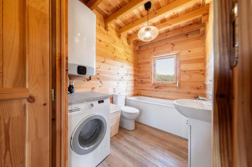 a bathroom with a washing machine and a sink at Dom nad Ińskiem in Scienne