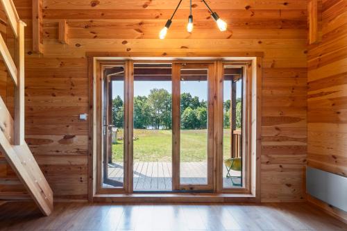an empty room with a large window in a log cabin at Dom nad Ińskiem in Scienne