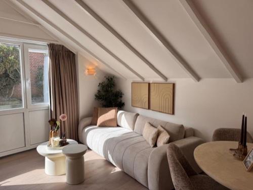 a living room with a couch and a table at Beach House Zandvoort in Zandvoort