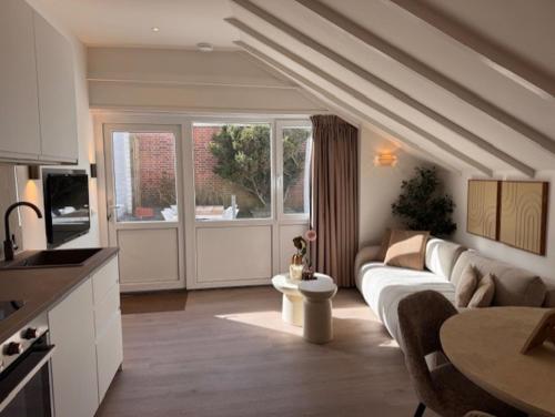 a living room with a couch and a table at Beach House Zandvoort in Zandvoort