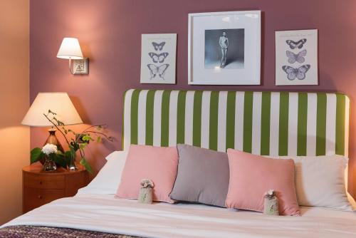 a bedroom with a bed with pink and white pillows at Areela Boutique Hotel in Tirana