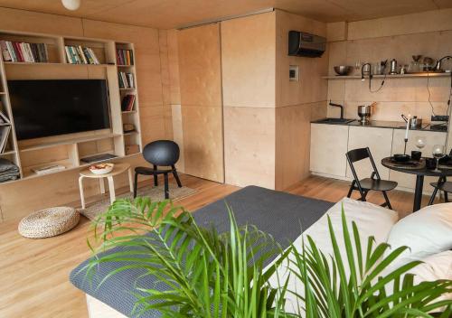 a living room with a couch and chairs and a tv at Domy w ogrodzie - Riverfront cabins in Poznań