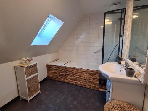 a bathroom with a bath tub and a sink at Le gîte "Hélaine" Charme, tranquillité, proche mer in Saint-Germain-sur-Ay