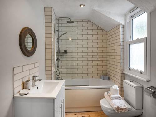 a bathroom with a tub and a sink and a toilet at Pandy Cottage in Aberdyfi