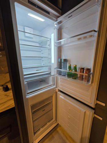 an empty refrigerator with its door open in a kitchen at Arjan Luxury Studio Pool View Near Miracle Garden in Dubai