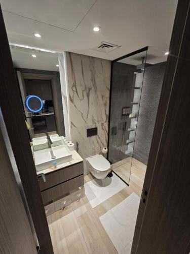 a bathroom with a toilet and a sink and a shower at Arjan Luxury Studio Pool View Near Miracle Garden in Dubai
