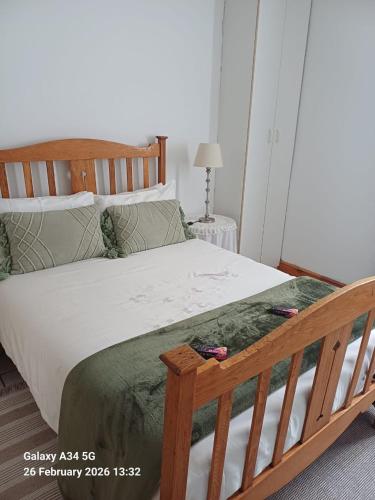 a bedroom with a large bed with a wooden frame at 21A On VDR in Oudtshoorn