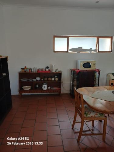 a living room with a table and a tiled floor at 21A On VDR in Oudtshoorn