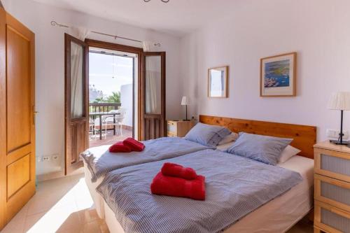 a bedroom with a bed with red pillows on it at Marina d'Or III - Villa 10 in Santanyi