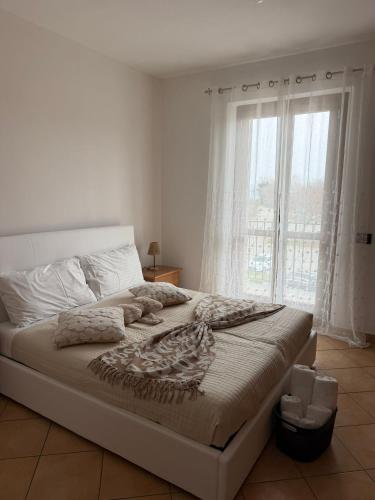 a bedroom with a large bed with a large window at Casa Speranza in Narzole