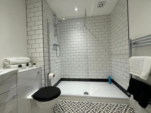a bathroom with a black toilet and a shower at Stylish 2 Bedroom Coastal Apartment near Crosby Beach & Liverpool in Waterloo