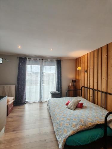 a bedroom with a bed and a large window at Gites du Rioul in Les Estables