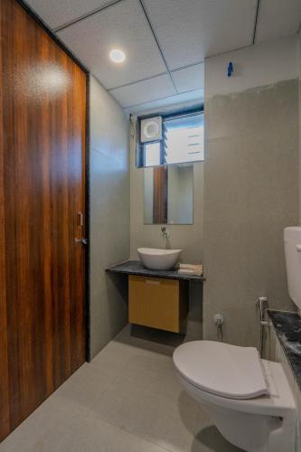 a bathroom with a toilet and a sink at hotel mon ville alkapuri in Vadodara