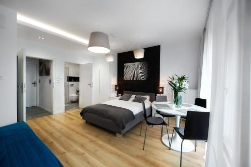 a bedroom with a bed and a table and a dining room at Kalia Apartments in Warsaw