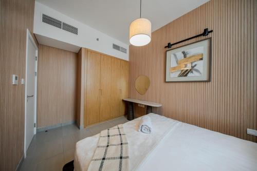 a bedroom with a bed and a picture on the wall at The Clay Loft Stylish 1BR with Pool Parking CB2-1-RA2-707-1br in Sharjah