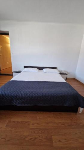 a bedroom with a large bed with a blue blanket at Casa Ioanele in Valea Perilor