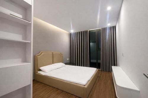 a small bedroom with a bed and a window at BRG Luxury Apartments in Hai Phong