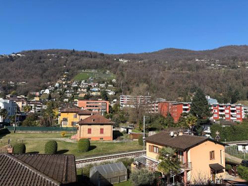 a view of a city with buildings and a mountain at Lake Agno Apartment in Agno