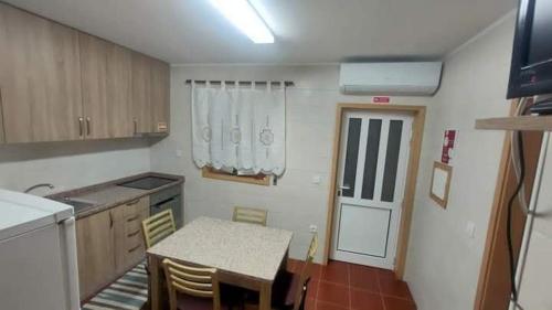 a kitchen with a table and a table and a door at Casa Da Clarinha in Castelo de Paiva