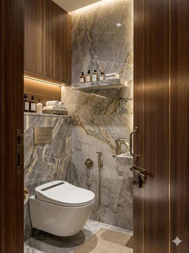 a bathroom with a white toilet and marble walls at Hotel DSR Park Near igi Airport Delhi in Majhera