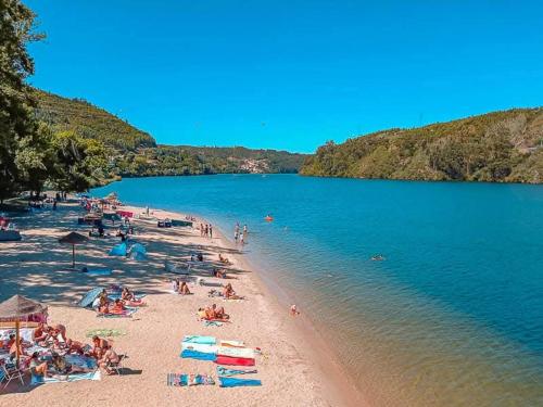 a group of people on a beach near the water at Casa Da Clarinha in Castelo de Paiva