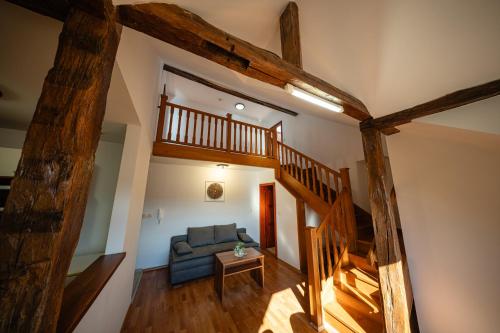 a living room with a blue couch and a wooden staircase at Penzion U Holuba in Hradčovice