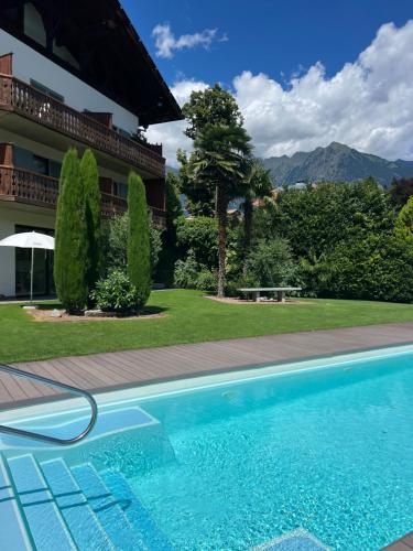 a swimming pool in front of a house at Hotel Traubenwirt in Marlengo