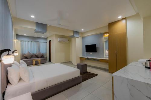 a hotel room with a bed and a television at hotel mon ville alkapuri in Vadodara