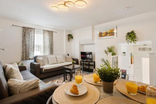 a living room with a couch and a table with orange juice at Comfortable Peckham Stay - Steps from Peckham Rye in London