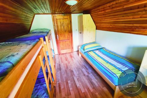 two bunk beds in a room with a door at Chata MIMONKA in Dedinky