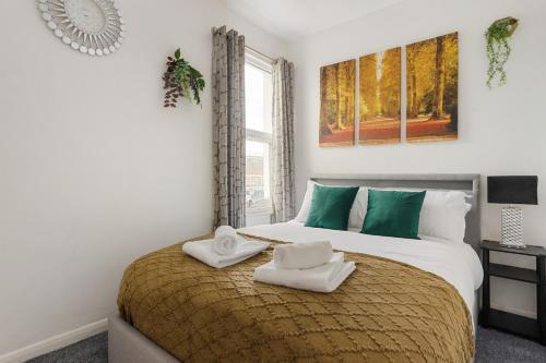 a bedroom with a large bed with towels on it at Comfortable Peckham Stay - Steps from Peckham Rye in London
