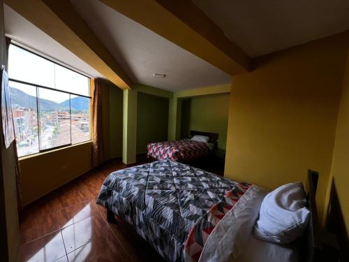 a hotel room with two beds and a large window at Refugio del Valle del Sol in Urubamba