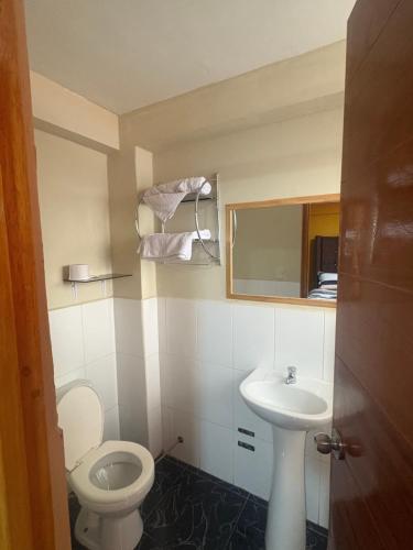 a small bathroom with a toilet and a sink at Refugio del Valle del Sol in Urubamba