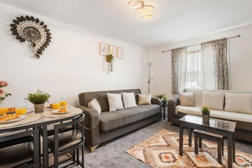 a living room with a couch and a table at Comfortable Peckham Stay - Steps from Peckham Rye in London