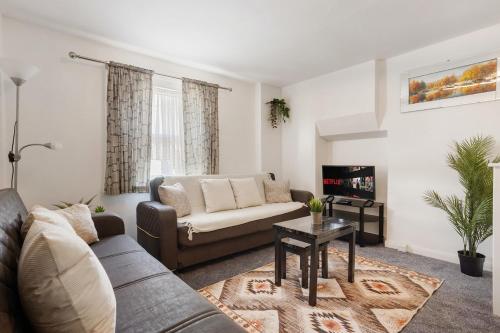 a living room with a couch and a tv at Comfortable Peckham Stay - Steps from Peckham Rye in London