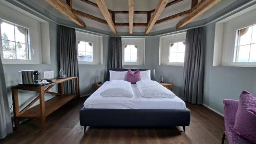 a bedroom with a large bed with pink pillows at Hotel De la Paix in Lucerne