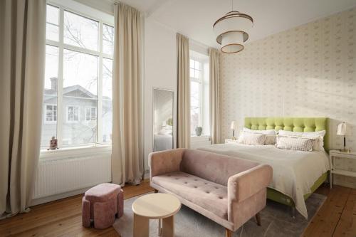 a bedroom with a bed and a couch and windows at L Boutique Hotel in Lysekil