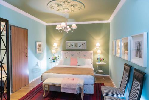 a bedroom with a bed with a chair and a chandelier at Areela Boutique Hotel in Tirana